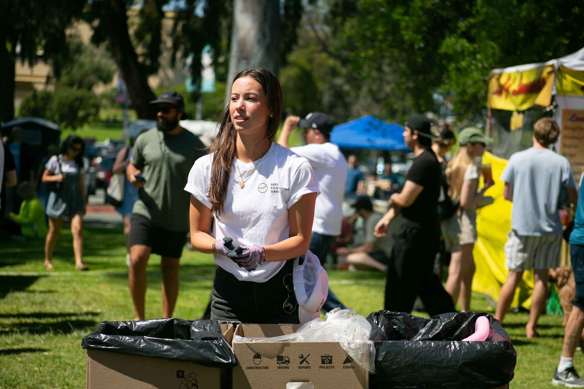 A woman sorts recycling and composted materials from trash during an outdoor event