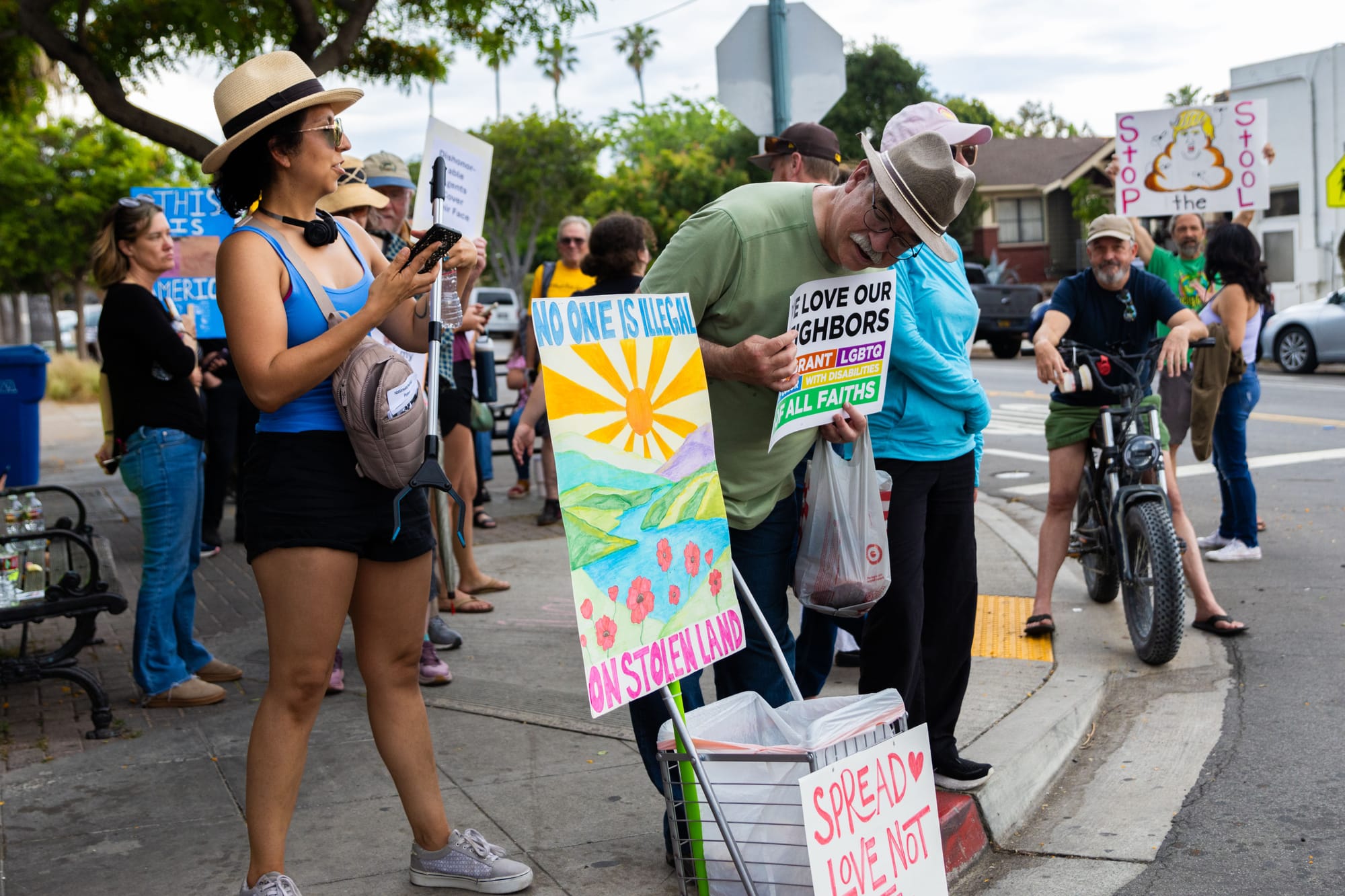 People hold signs while protesting outside