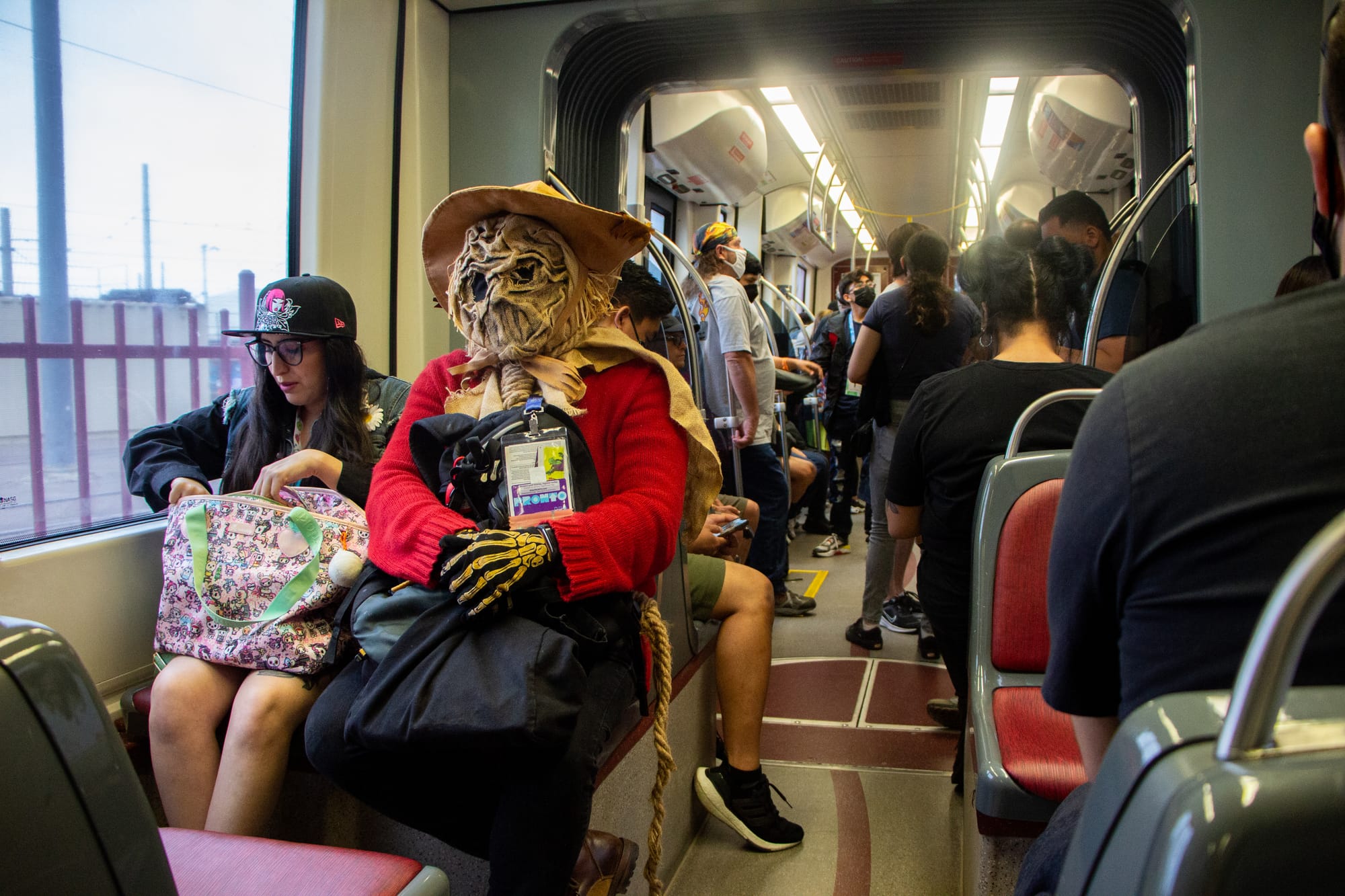 people ride a trolley, with one person in a scarecrow costume