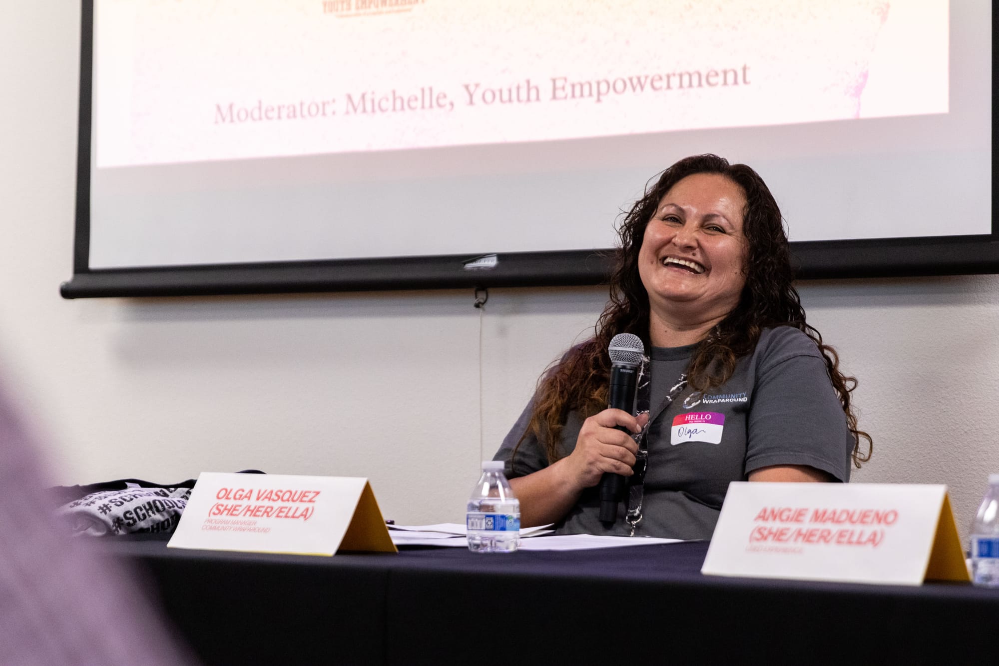 A woman laughs sitting at a panel