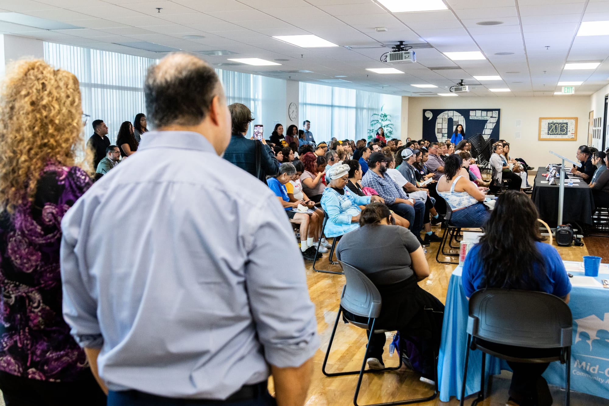 People sit in a crowd listening to a panel