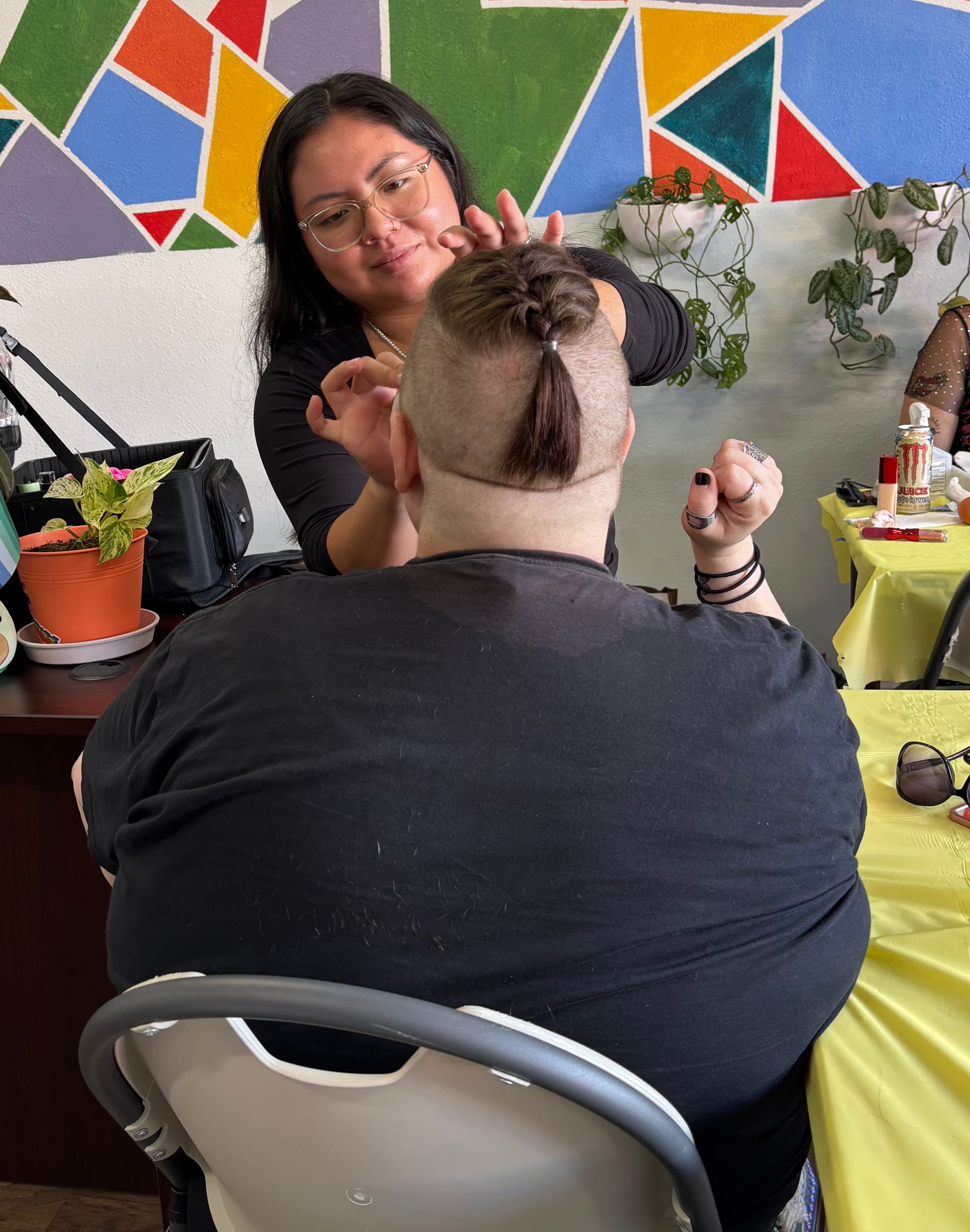 A person gets their hair cut at an event