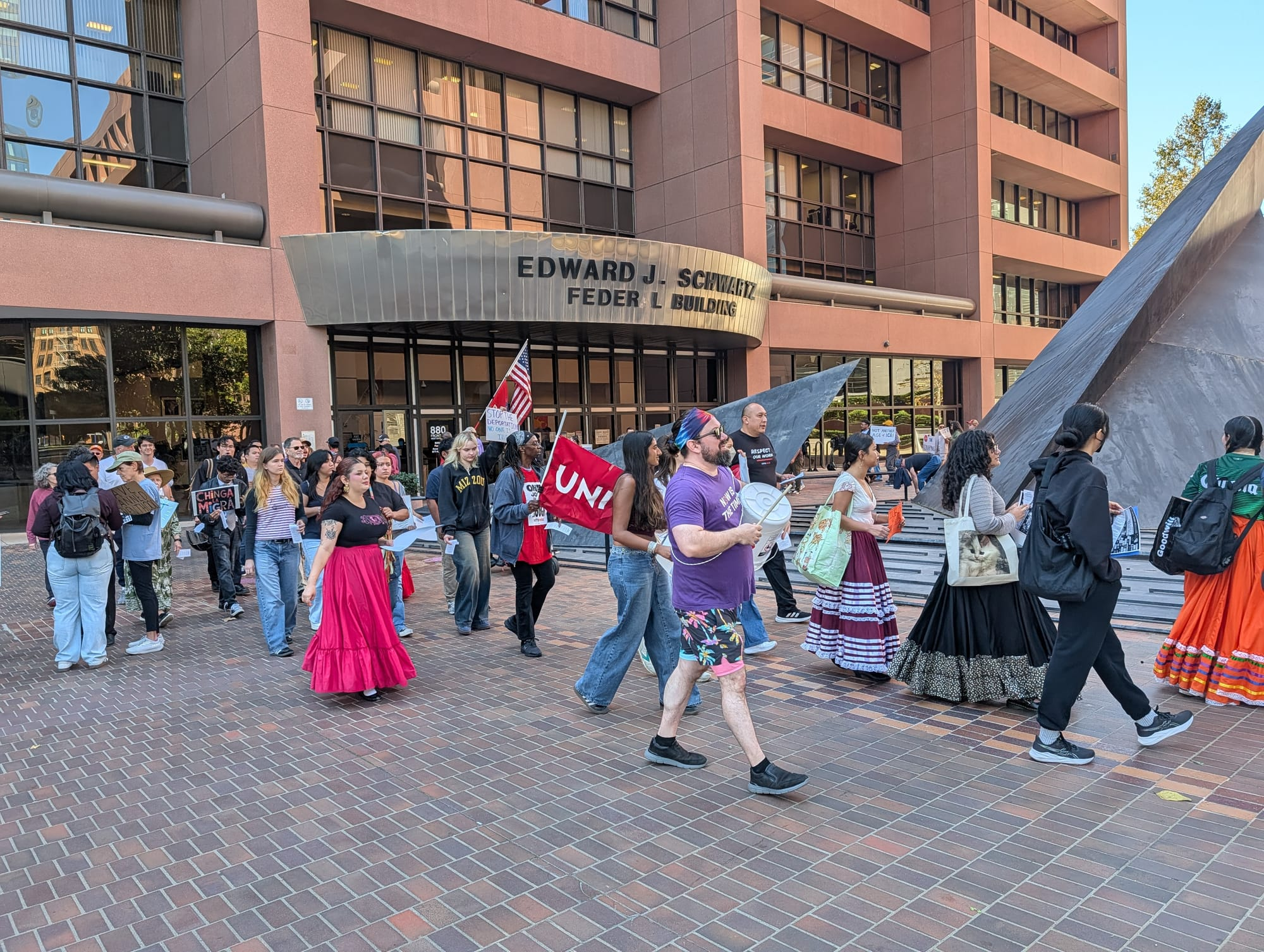 People circling the Edward J. Schwartz Federal Building in downtown San Diego.