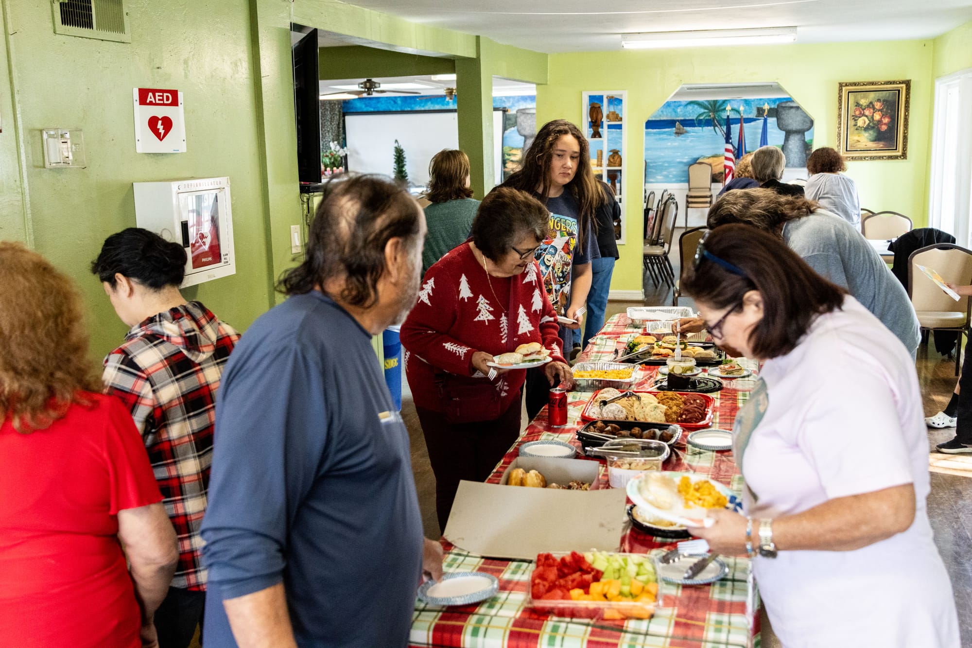 People crowd around a table to collect food. 