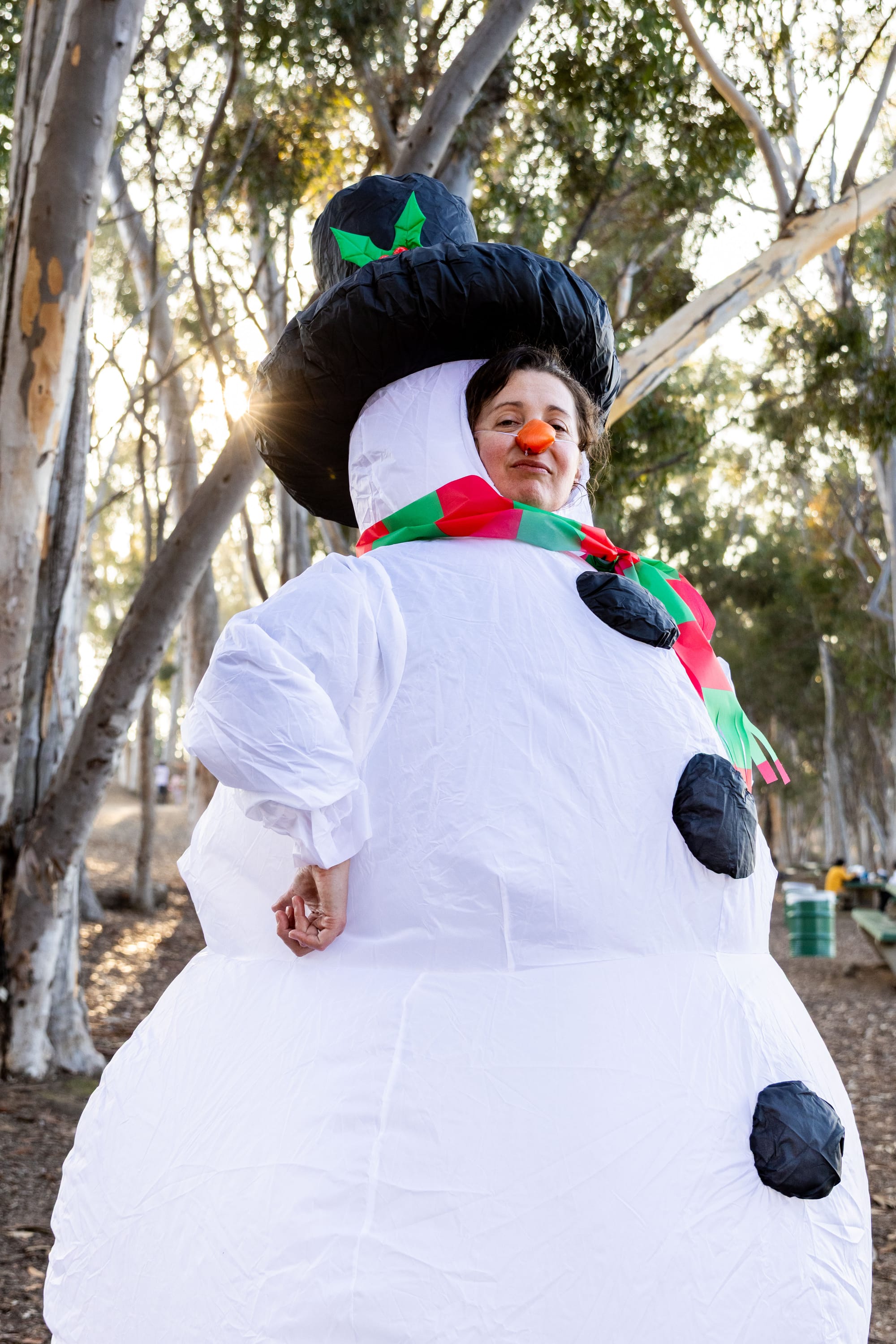 A person poses for a photo while dressed in a snowperson costume.