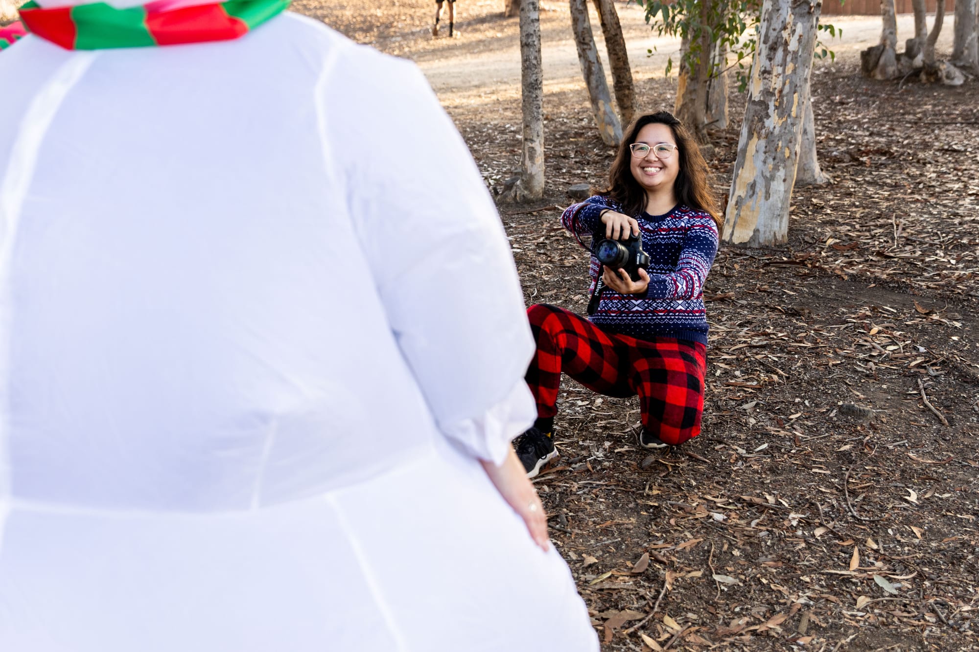 A person photographs someone dressed in a snowperson costume.