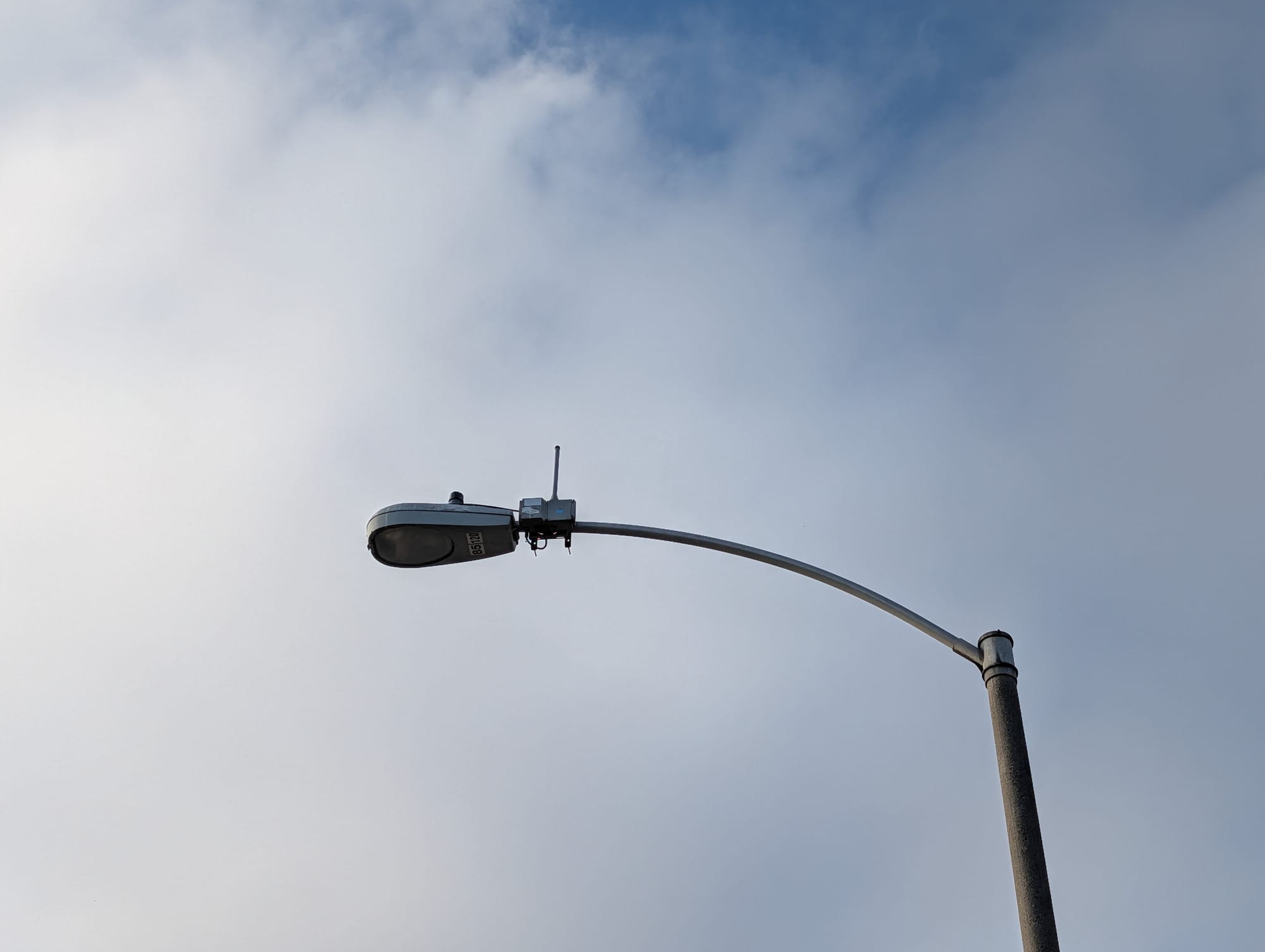 A smart street light in front of clouds in the sky