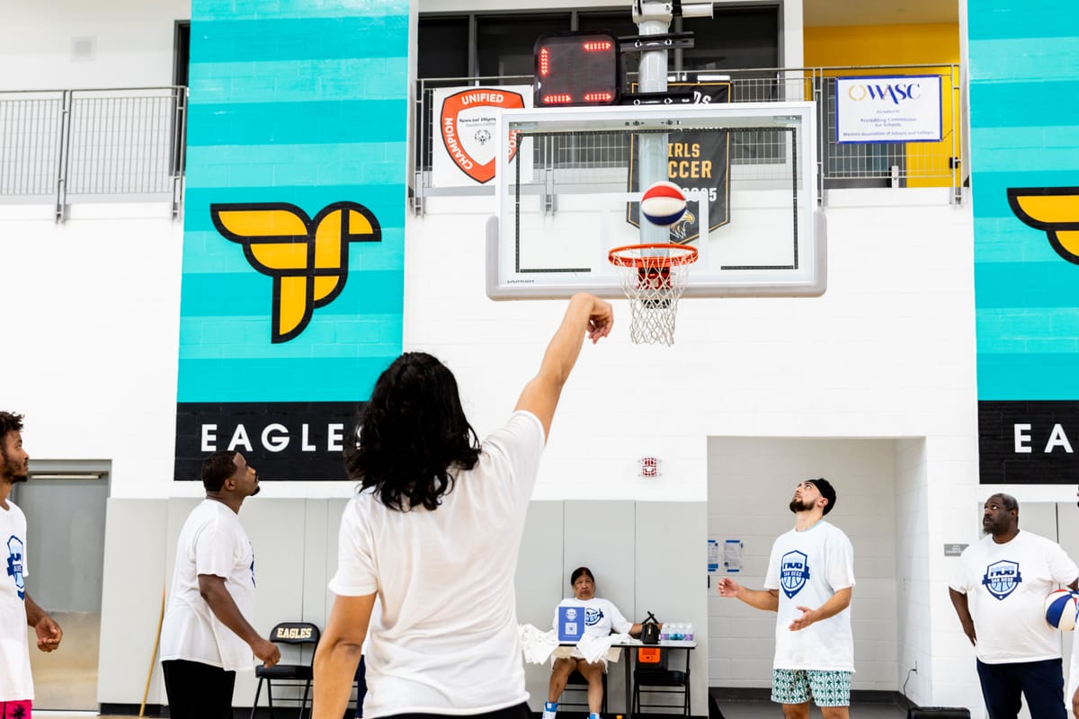 Image of the back of a basketball player as he shoots a freethrow shot.