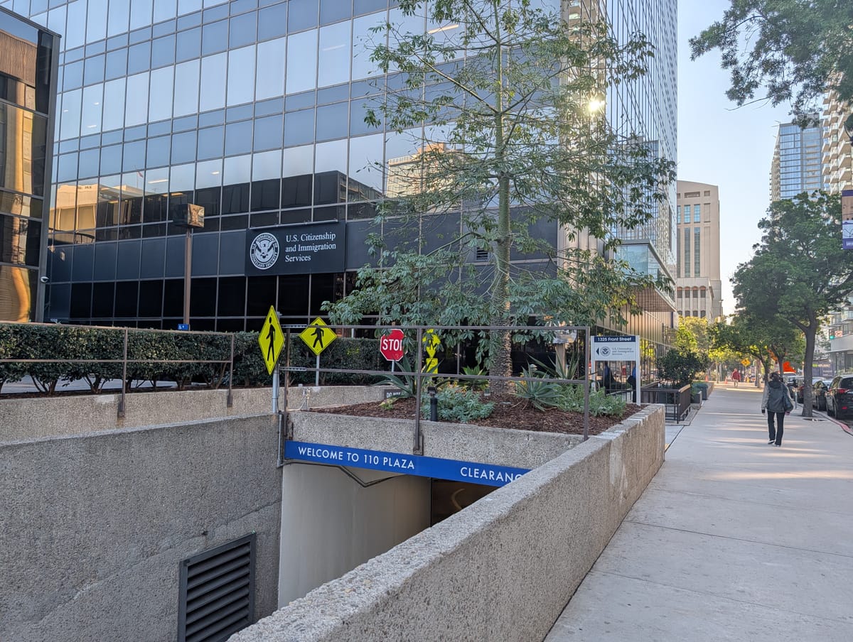 Picture of buildings, one with a sign that says "U.S. Citizenship and Immigration Services" on it.