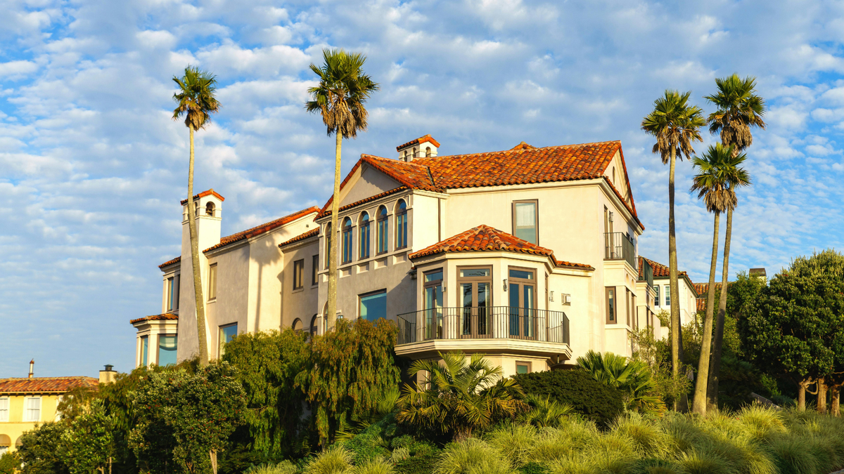 Picture of a mediterranean style house on a hill next to palm trees