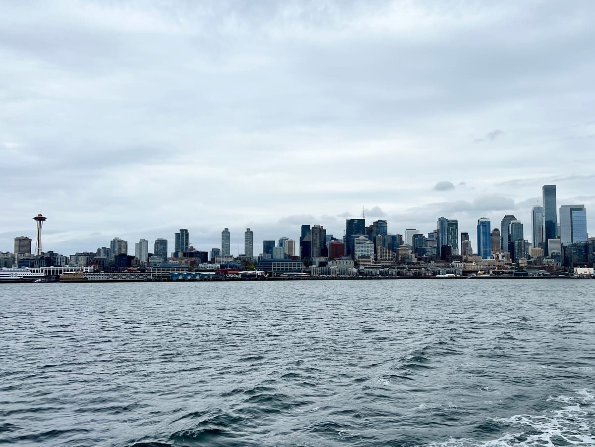 Picture of a city skyline over a body of water with the space needle to the left.