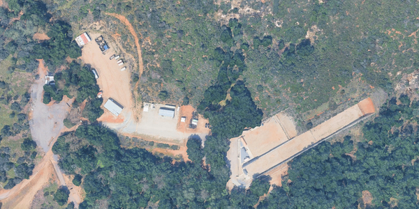 A dirt parking lot and long dirt firing range are visible from a bird's eye view.