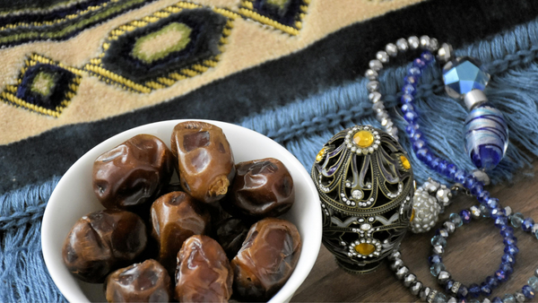 A picture of dates, a prayer mat and prayer beads