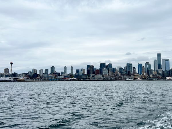 Picture of a city skyline over a body of water with the space needle to the left.
